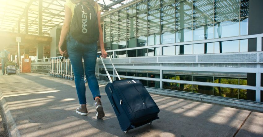 Suitcase - Woman Walking on Pathway While Strolling Luggage