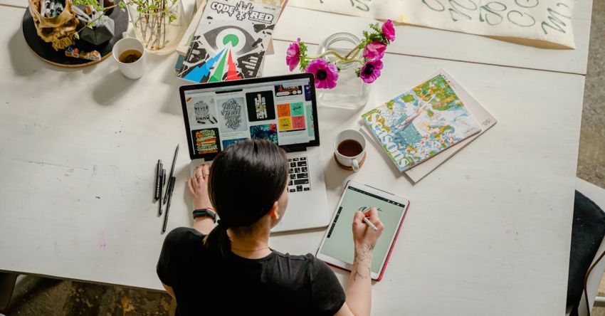 Experience - Photo of Woman Writing on Tablet Computer While Using Laptop