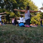 Activities - Women Performing Yoga on Green Grass Near Trees